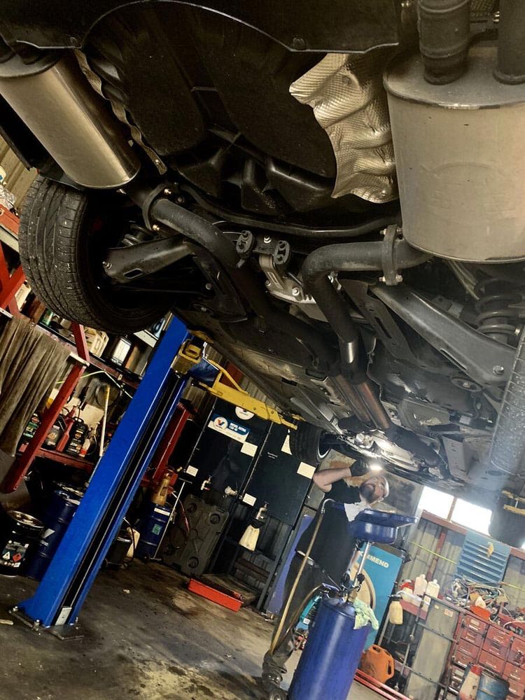 Joe's Auto Service Centre inspector performing a rego check on a car's undercarriage