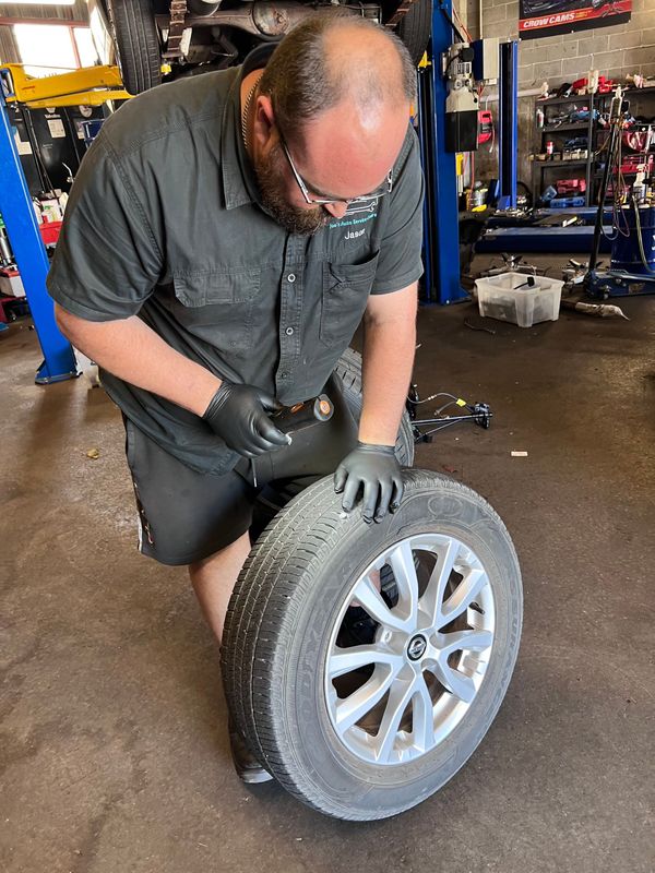 Mechanic inspecting a tyre at Joe's Auto Service Centre